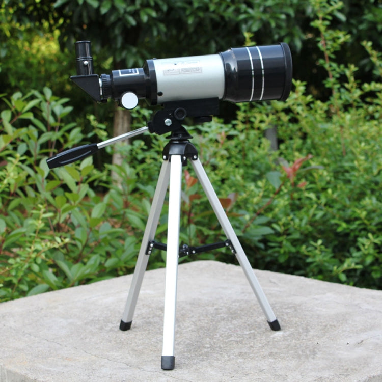 Astronomical telescope on silver tripod outdoors, black-and-silver optical tube