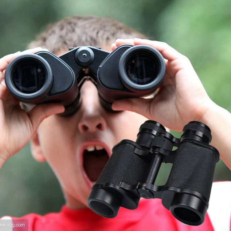 Handheld black binoculars held up to eyes, showing objective lenses and eyecups