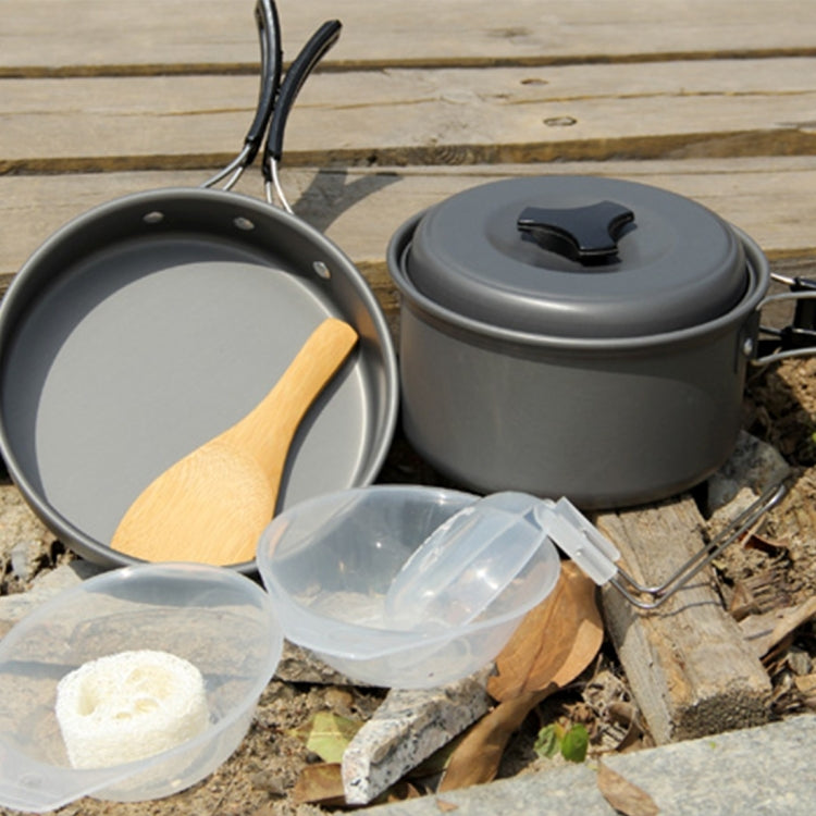 Camping cookware set with two dark gray pots, black lid, and clear nested cups