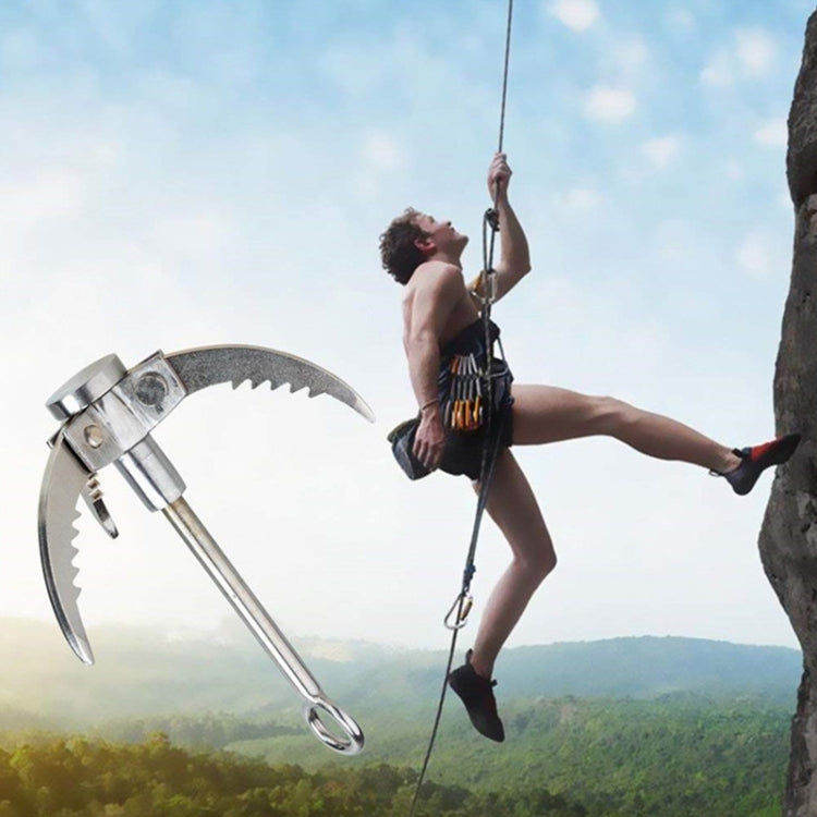 Three-claw folding grappling hook with carabiner loop while climbing outdoors.