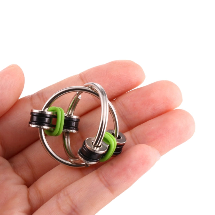 Tri-spinner key ring toy in hand, green silicone rings with rotating metal spinners