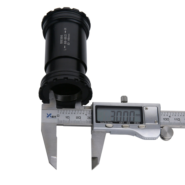 Black bottom bracket shell measured with digital caliper, open end and side markings visible