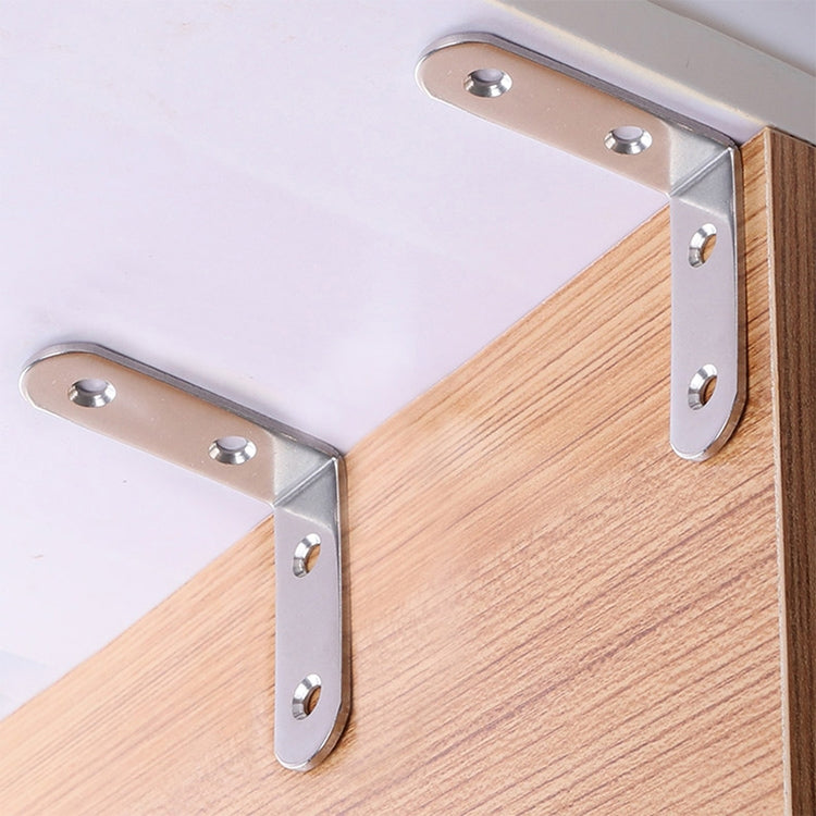 Stainless steel corner braces mounted on a wooden panel with screws through holes