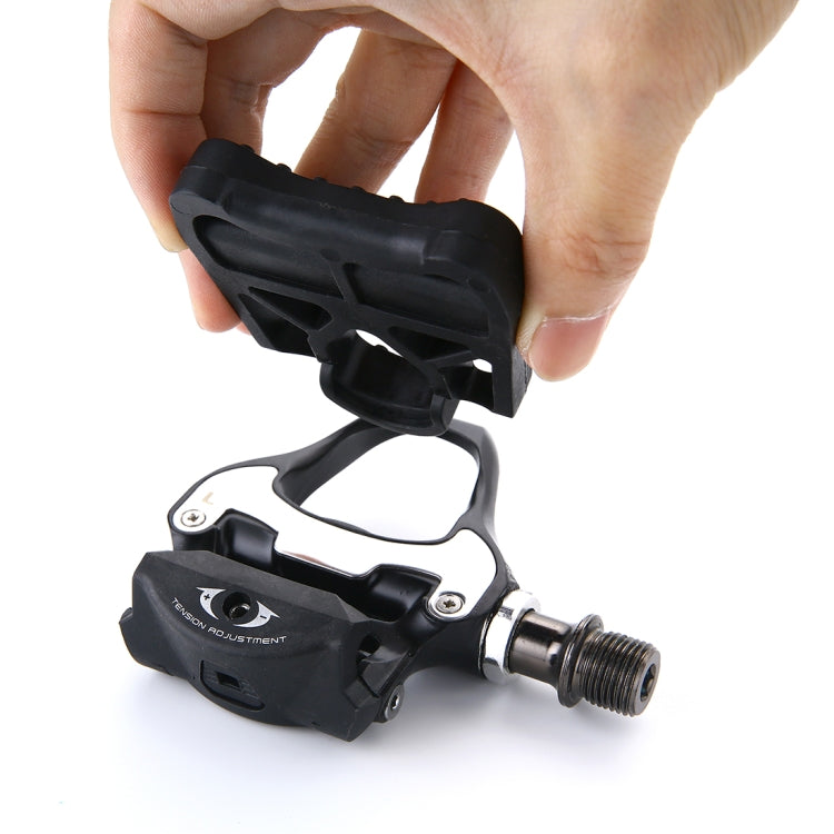 Handheld black locking road bike pedals with KEO-style cleat adapter and axle threads