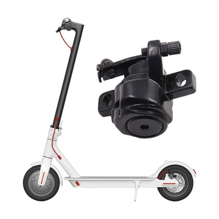 Black disc brake caliper mounted on scooter wheel with disc rotor