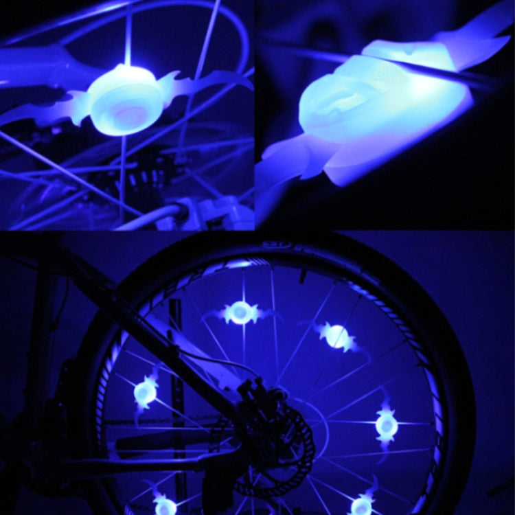 Blue LED bicycle spoke lights glowing at night on a wheel