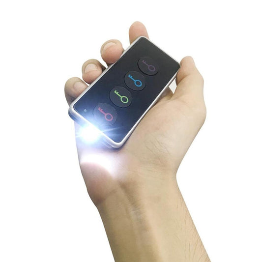 Wireless key finder remote held in hand with blue LED light and colored button indicators
