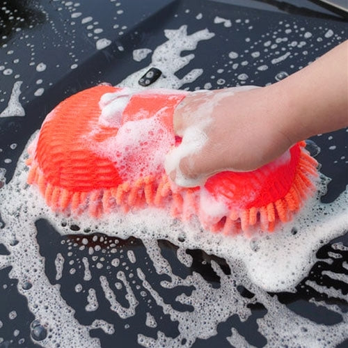Orange-red chenille car washing brush scrubbing a foamy car surface