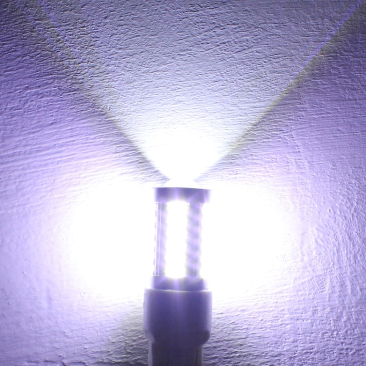 H7 LED car bulb glowing bright white through clear lens, with pin base
