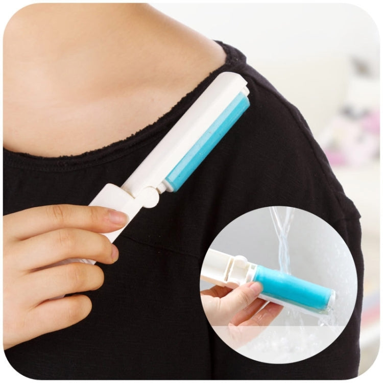 Portable mini sticky silicone hair remover with blue roller, shown on a dark shirt