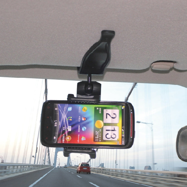 Black smartphone secured on visor mount holder inside the vehicle cabin