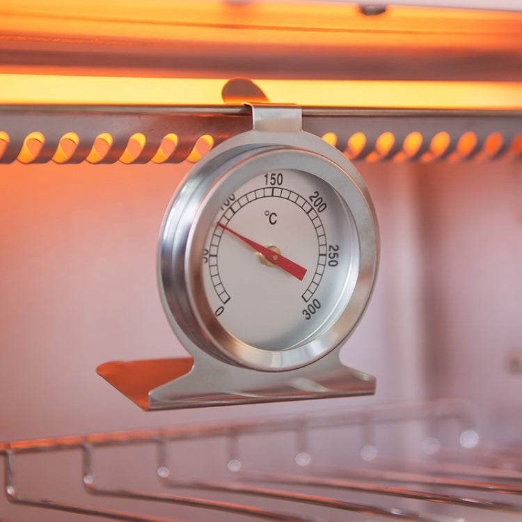 Stainless steel oven thermometer hanging in oven, round dial with red needle