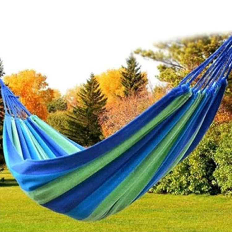 Single camping hammock with blue and green striped canvas fabric, spread wide.