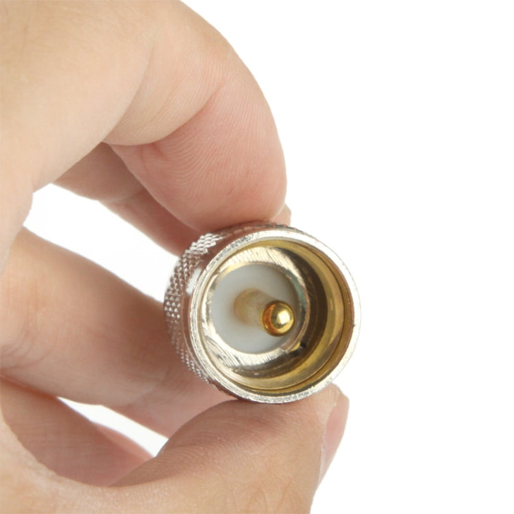 RF adapter tip held in hand, gold center pin and threaded connector opening