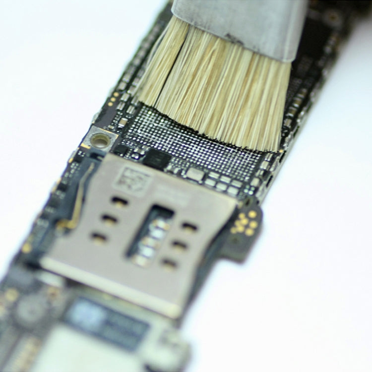 Pig hair brush bristles cleaning a circuit board surface