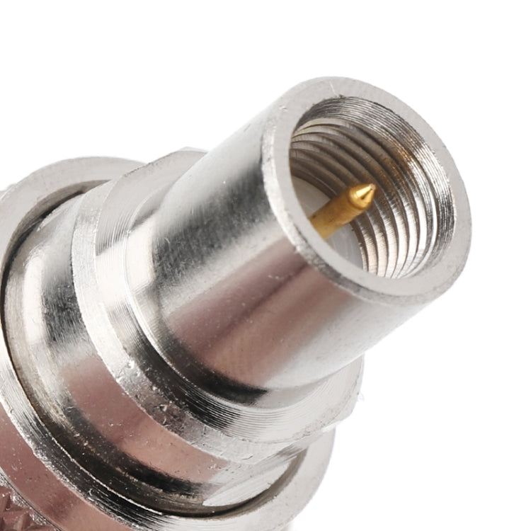 RF coaxial adapter close-up, silver metal, threaded connector with gold center pin
