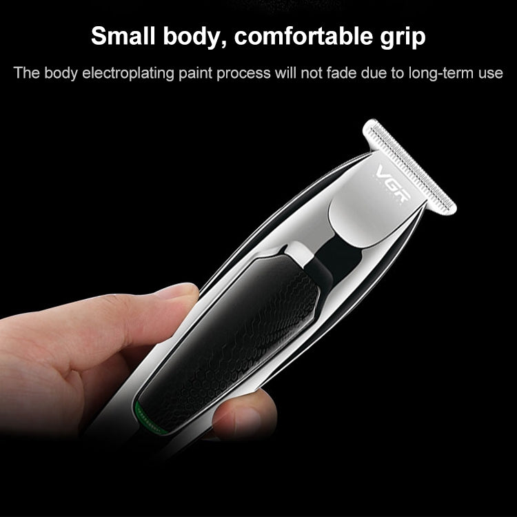 Electric hair clipper close-up with silver top, black textured grip, held in hand