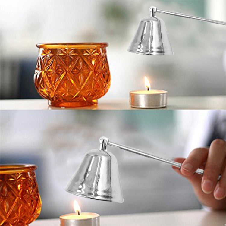 Chrome silver candle mask tool held by hand over a small burning candle