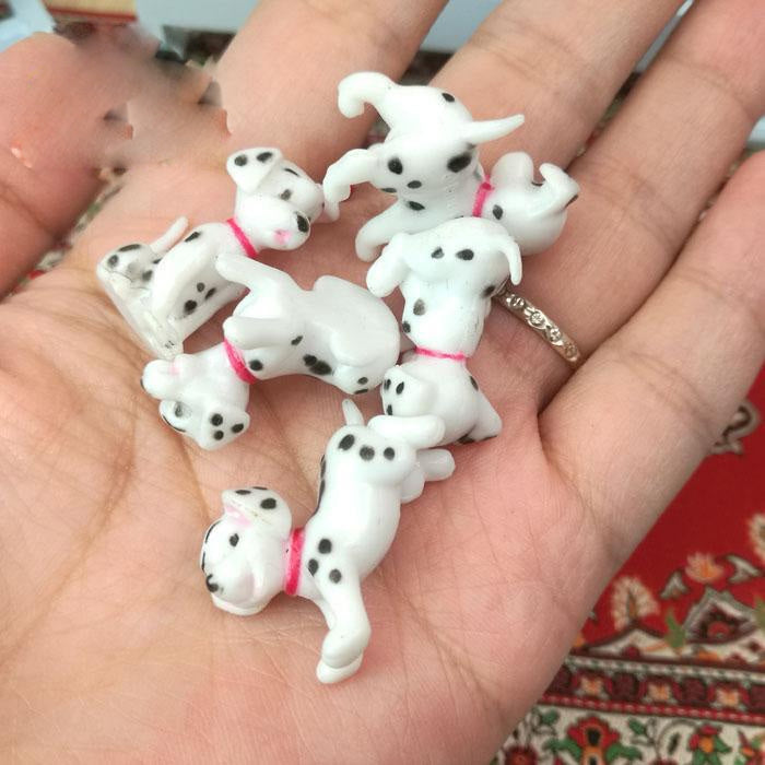 6-piece Dalmatian miniature toy set of spotted puppy figures in an open palm