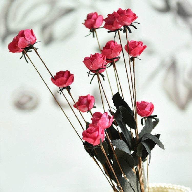 Artificial rose bud bouquet with red blooms and dark leaves