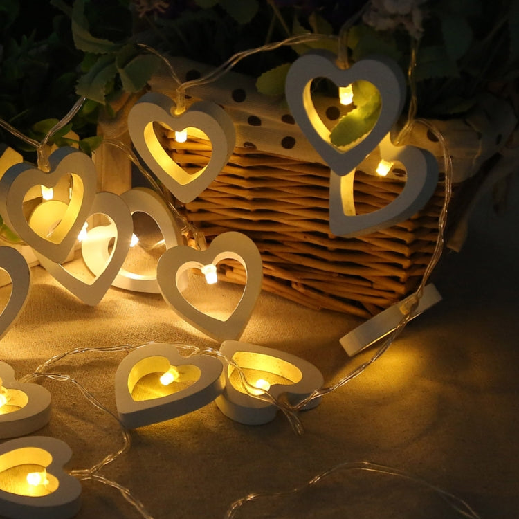 Glowing wooden heart LED string lights with heart cutouts hanging on the wire
