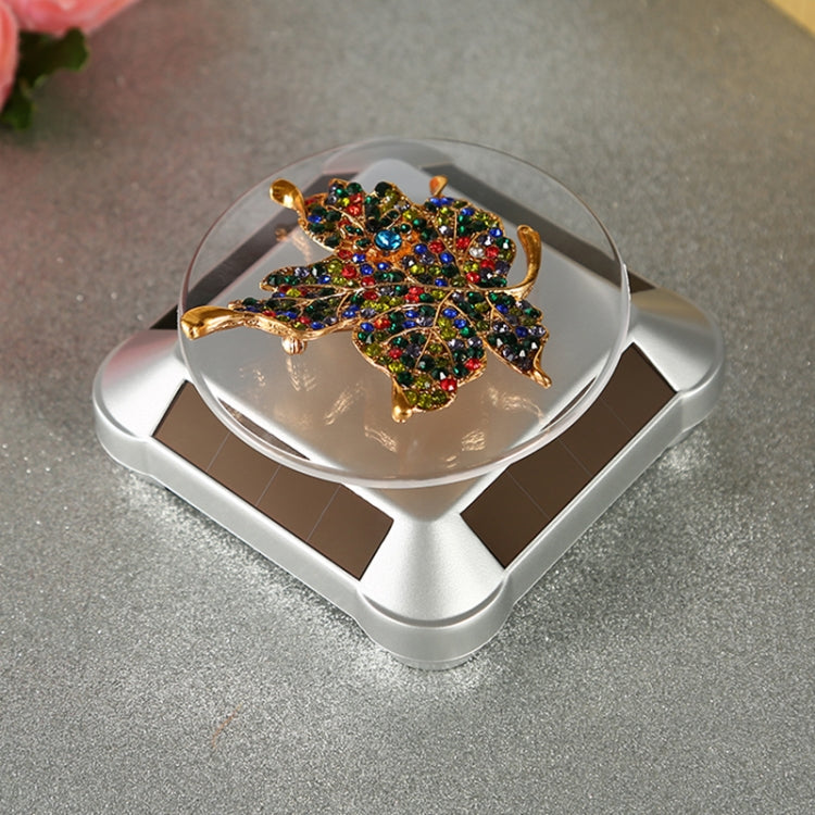 Automatic rotating display stand with clear glass round top and square base