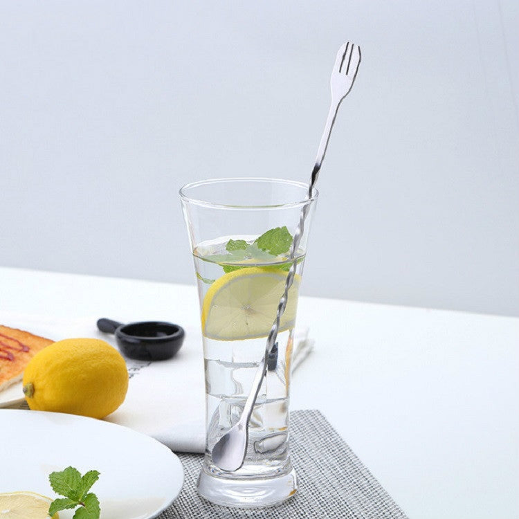 Stainless steel cocktail stirrer with fork end in tall drink glass