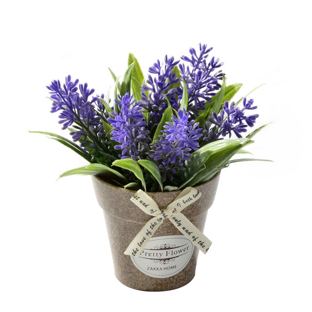 Artificial potted flowers with purple blossoms and green leaves in a gray fabric pot