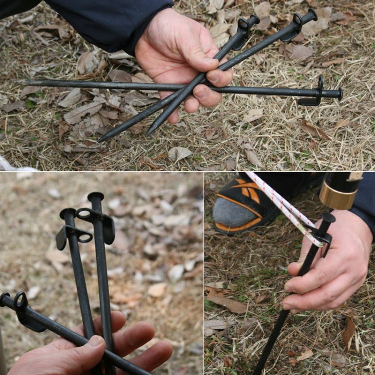 Black steel tent stakes held by hand for camping tent anchoring, pointed ends
