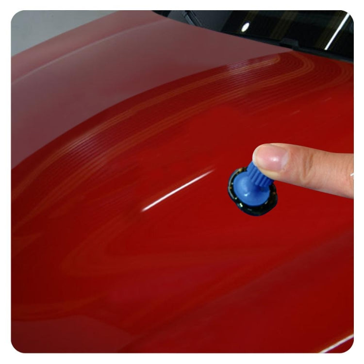 Blue suction cup dent repair puller sitting on a car hood surface