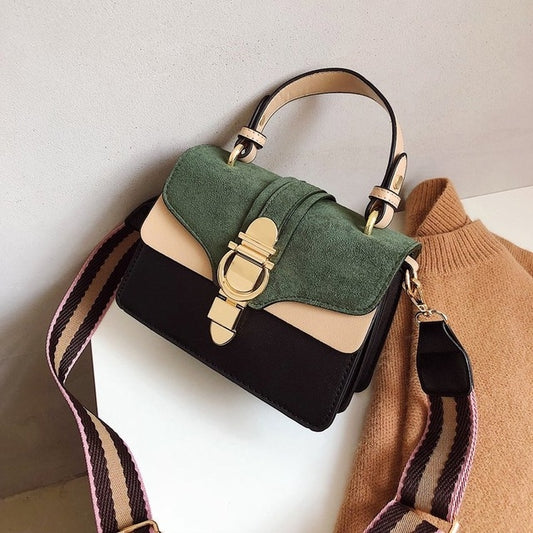 Green suede-look flap handbag with black body, gold clasp, and striped crossbody strap