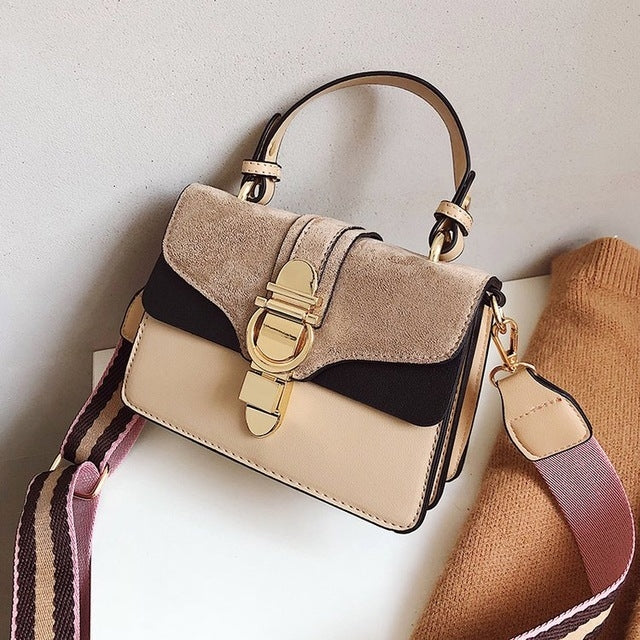 Beige and black leather flap crossbody bag with gold-tone buckle and striped strap