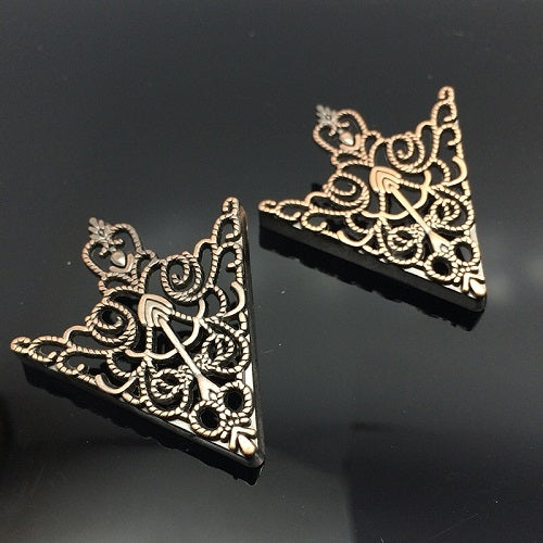 Two triangular collar buckles with crown-like filigree, antique bronze and gold tones