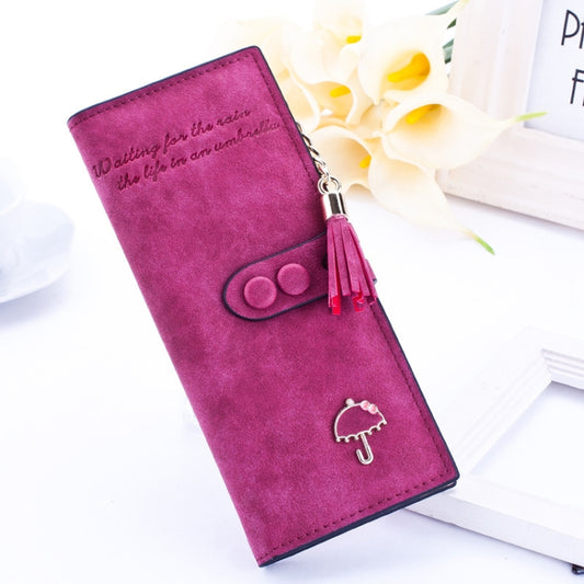 Women’s long zip wallet in dark pink/wine with umbrella emblem and tassel charm