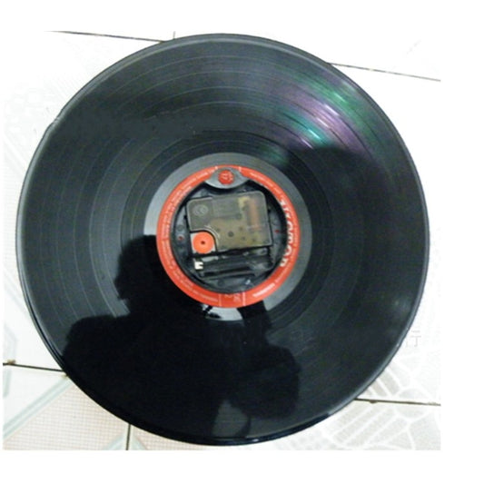 Vinyl record wall clock showing colorful inner label on a black record disc