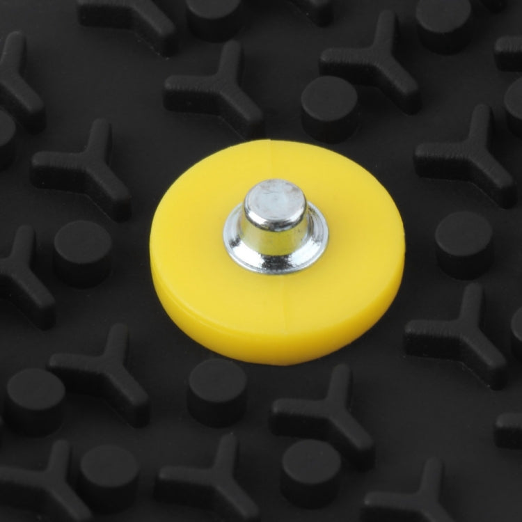 Yellow traction stud on black rubber ice cleat with silver screw head
