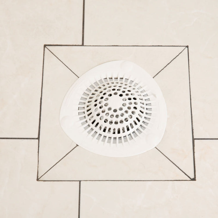 White silicone sink strainer hair catcher disc with circular perforations on tile