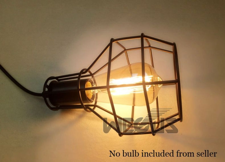 Close-up of retro pulley wall lamp with glowing bulb inside wire lantern cage
