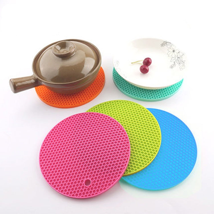 Set of round honeycomb silicone heat mats in orange, green, red, and blue