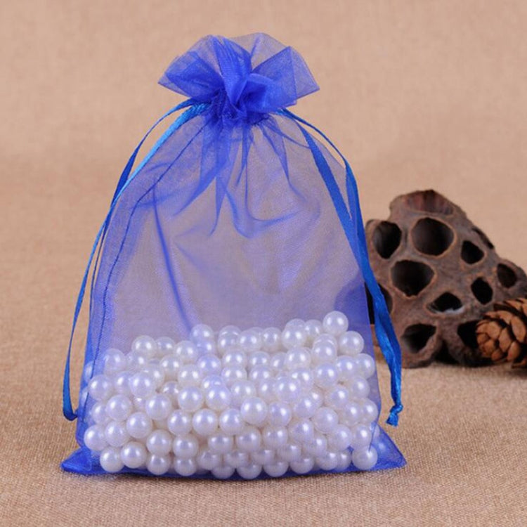 Blue organza drawstring gift bag with sheer bow, filled with white pearl beads