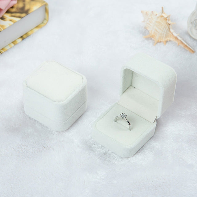 White velvet ring jewelry box set, one closed and one open with silver-toned ring