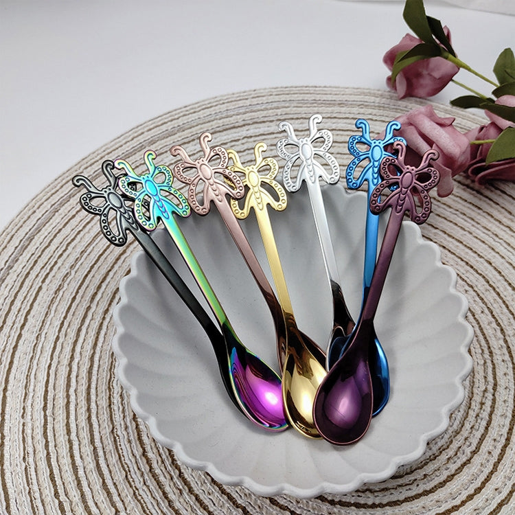 Multicolor butterfly dessert spoons in a fan arrangement on a white plate