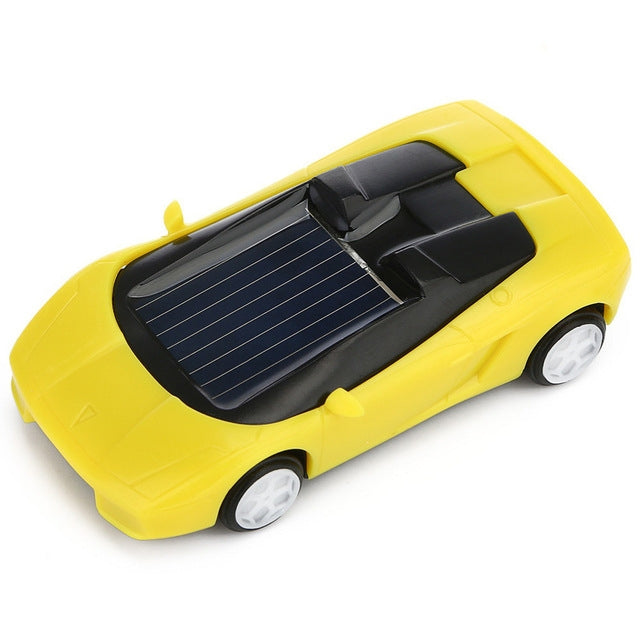 Yellow solar powered mini toy car with solar panel and white wheels, close side view