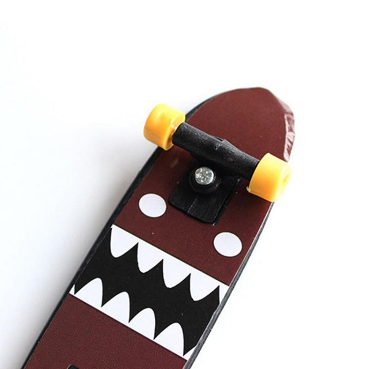Mini finger skateboard close-up: black truck, yellow wheels, brown and black graphic deck