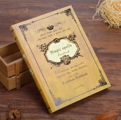 Yellow vintage pocket notebook with ornate spell text and decorative border cover.