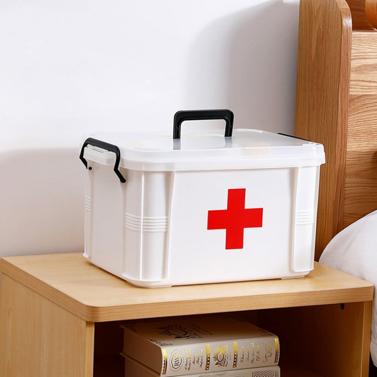White plastic medical storage box with red cross and black carry handle on counter