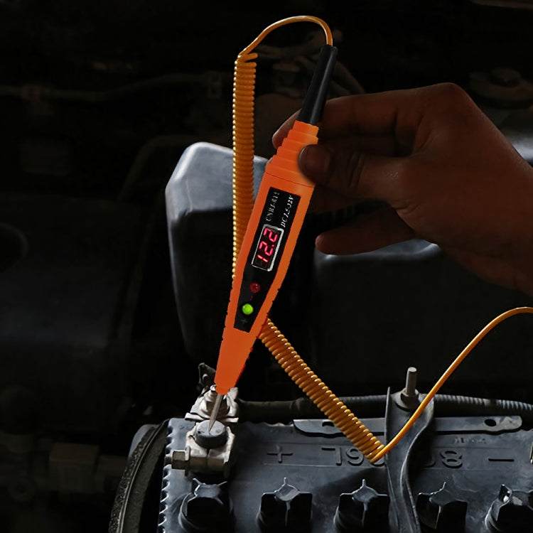 Digital car test pen with LCD screen used near car battery with probe tip