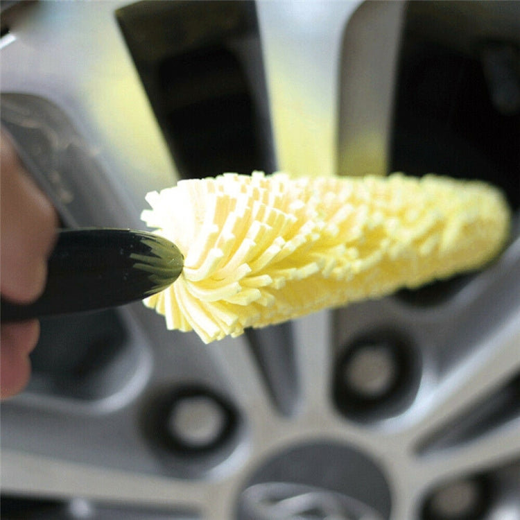 Close-up yellow sponge wheel brush head on black handle scrubbing a rim