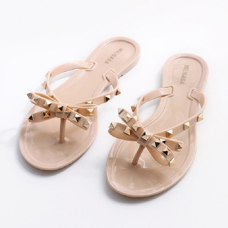 Apricot slip-on flat sandals with rhinestone bow detail across the toe straps