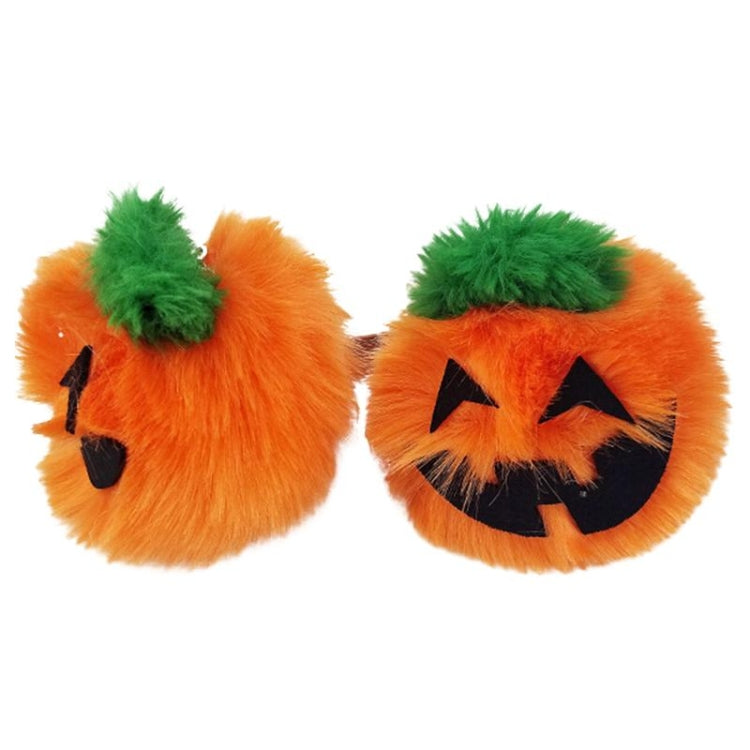 Two pumpkin-shaped plush keychains with orange fur, green tufts, and black jack faces